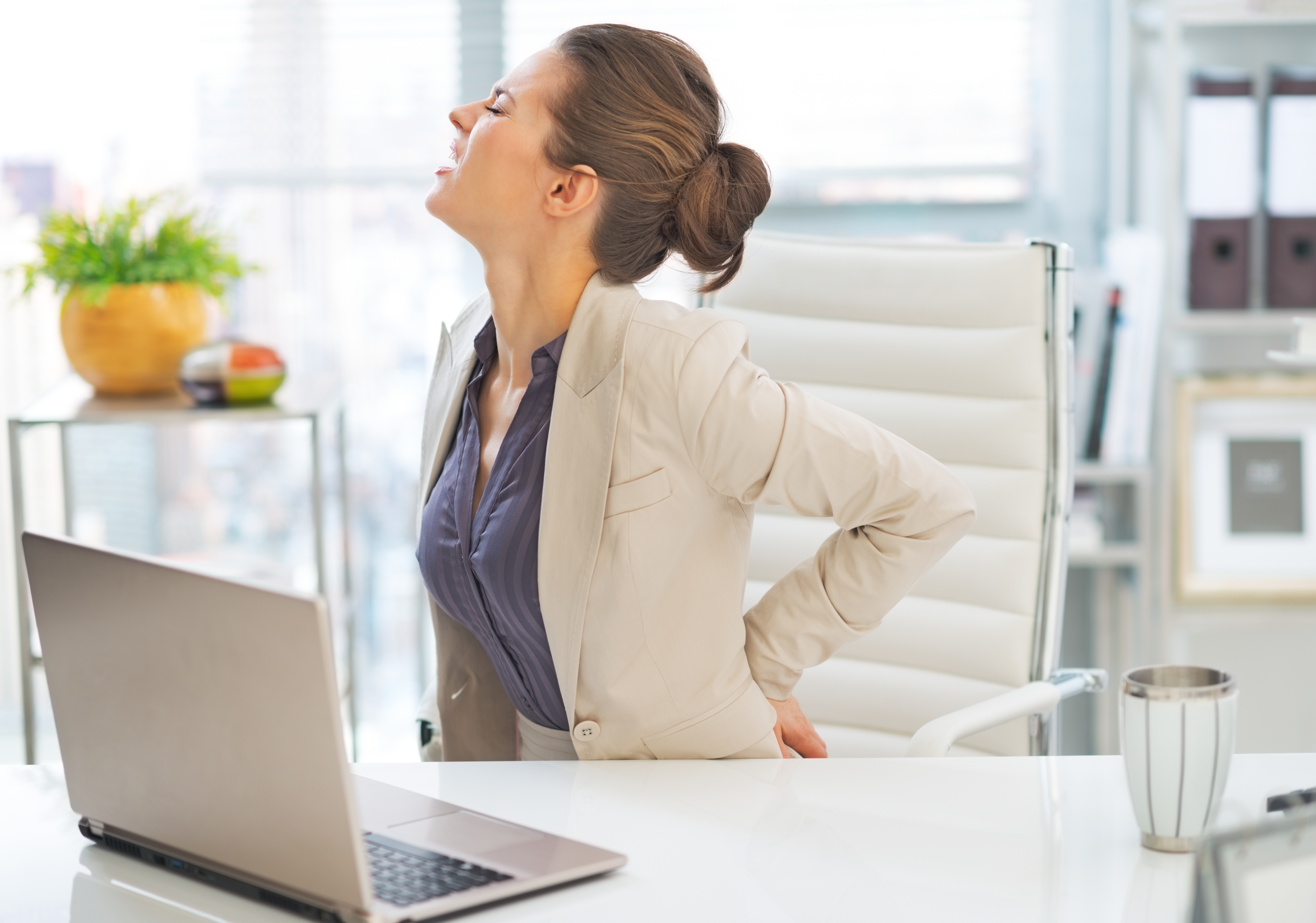 Portrait of business woman with back pain in office
